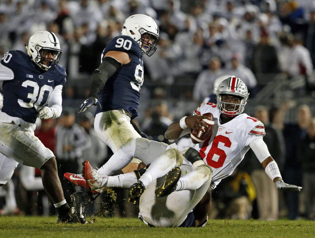 Ohio State quarterback J.T. Barrett (16) is sacked by Penn State's Jason Cabinda, behind, during the second half of an NCAA college football game in State College, Pa., Saturday, Oct. 22, 2016. Penn State won 24-21. (AP Photo/Chris Knight)